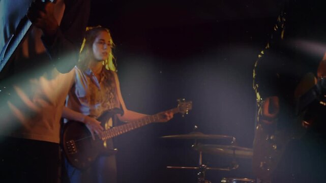 Camera pulling back revealing music band, playing for energy, singer at mic, bassist locking groove