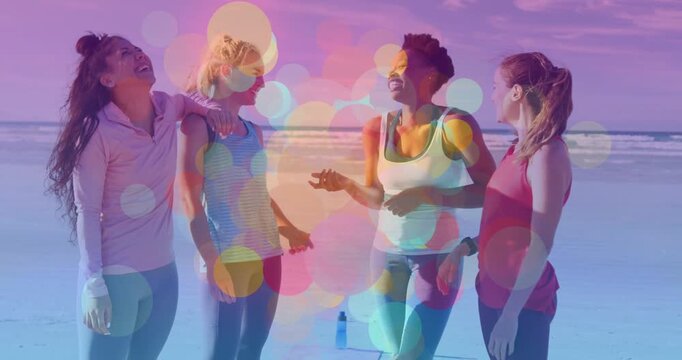 4 women on shore speaker gesturing drawing smiles in fitness chat bokeh avoiding faces water bottle