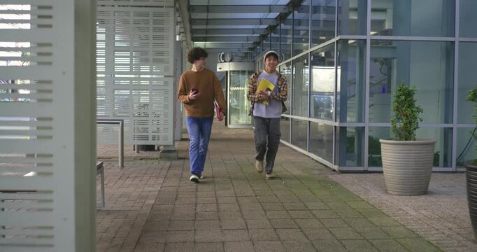 Diverse men walking walkway Asian man spotting curb running ahead with folders peer checking phone