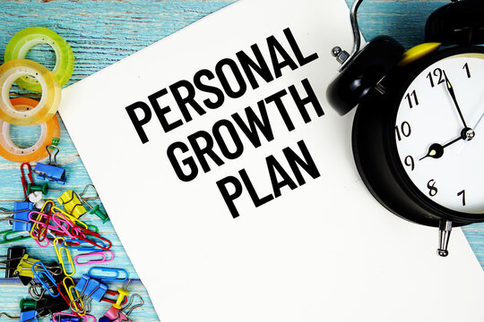 Personal Growth Plan text on a paper surrounded by office supplies and a clock on a blue wooden surface