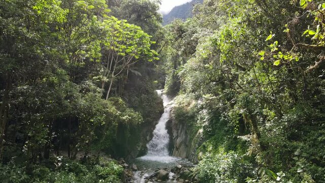 Aerial Aerial Drone Slow Approach to Mandor Waterfall in the lush green jungle near Machu Picchu, Peru. Pristine mountain stream and waterfall in the heart of the Peruvian cloud forest.