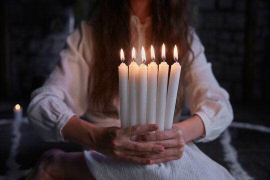 Crop of woman practitioner immersed in ritual using old books and ceremonial objects