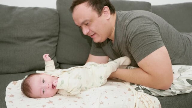 man talk with infant at home, happy parent (father and mother) talking and playing with infant . High quality 4k footage