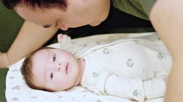 man talk with infant at home, happy parent (father and mother) talking and playing with infant . High quality 4k footage