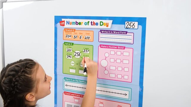Curious girl interacts with a visual numbers table on a magnetic board. High-resolution 4K video footage showing the cognitive growth and learning process of a preschool student.