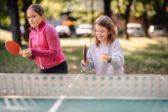 Girls playing table tennis having fun outdoor