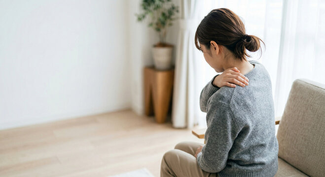 肩を押さえる女性　肩凝り、疲れ
