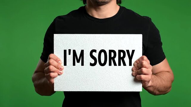 Man holding I'm sorry sign board.
