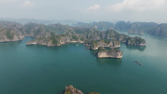 Cat Ba Vietnam drone panorama of karst islands rising from a turquoise expanse, with multiple bays and channels visible.