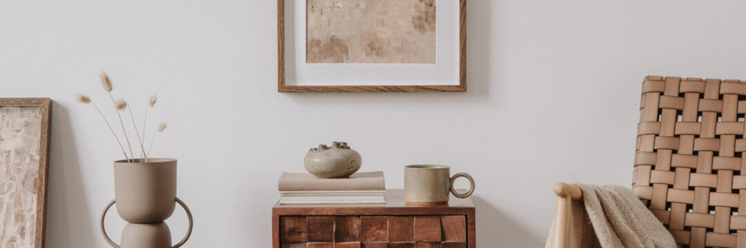 Elegant comosition of masculine room decor with small wooden cupboard, two mockup paintings and vintage accessories. Home staging. Template. Copy space.