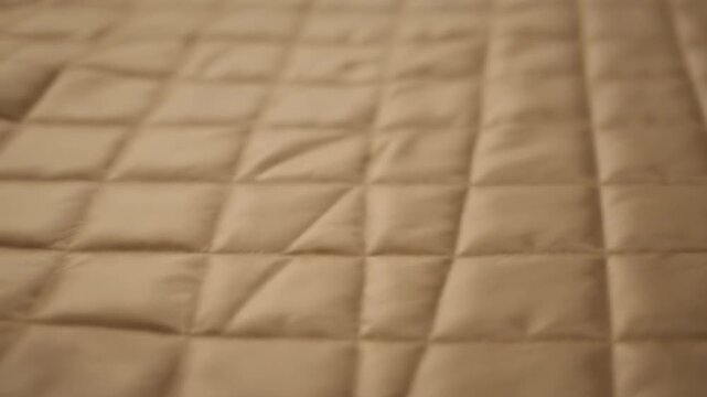 Close-up of a quilted fabric with a diamond pattern.