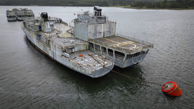 Aerial view of the mothballed warships creating a stark contrast between their aged metal and the serene, reflective waters, Landevennec, France.