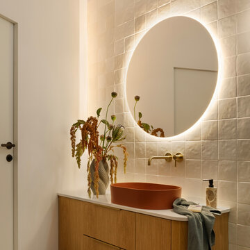 Elegant Bathroom with Round Illuminated Mirror and Vanity