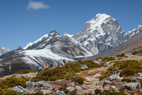 Group hikers with backpacks walking mountain trail during a hike of the Trekking on Trail to Everest Base Campduring, Nepal.