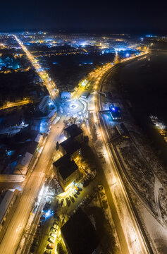 Aerial view of streets bathed in golden light, cutting through the inky blue darkness of night, illuminating the heart of the city, Sremska Mitrovica, Vojvodina, Serbia.