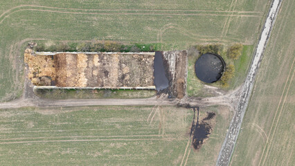Manure storage tank lagoon pit submerged slurry collect and store liquid livestock pollution contamination groundwater solid waste bedding straw or corn stalks stored pile stinking unpleasant smell © Tomas Vynikal