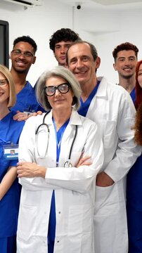 Confident and diverse group of healthcare professionals, including doctors and nurses, smiling together while posing in a modern clinic, showcasing teamwork and dedication in the medical field