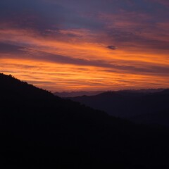 Obraz premium Golden Orange Sunset Over Mountain Silhouette Landscape