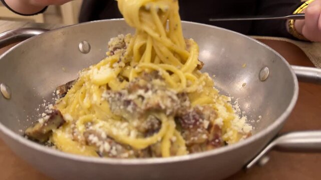 Woman with red nails eating delicious creamy spaghetti with a fork and spoon, with a healthy avocado burger and fresh juice on the restaurant table, revealing a focus on modern cuisine.4k