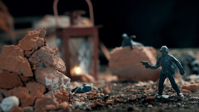 Plastic toy soldiers reenacting a battle in a miniature war zone. A detailed diorama with rubble, debris, and a lantern glowing at night