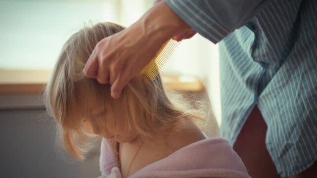 With gentle precision, a loving mother tenderly combs her child's tangled locks, carefully crafting adorable ponytails that showcase the heartwarming daily bonding ritual of parent and child