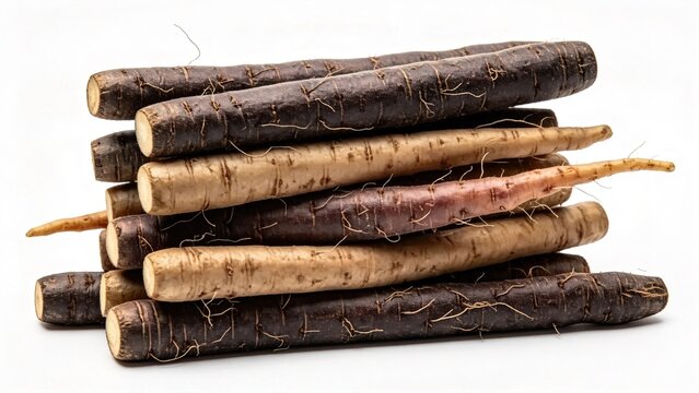 Assorted organic salsify root vegetables also known as oyster plant stacked in a pile on a white background showcasing purple beige and pink varieties for healthy cooking vegan mea