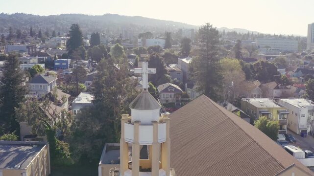 Drone shot of a church cross on top of a church in the city of Oakland, California.