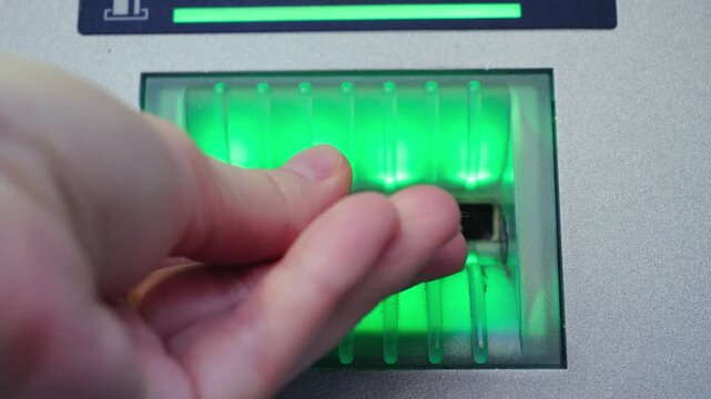 Close-up of hand inserting credit card into ATM. Banking, payment and financial transaction concept. High quality 4k footage