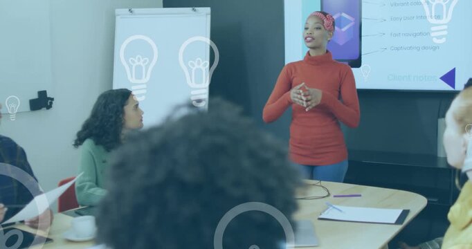 Animation of light bulb icons over diverse business people working in office