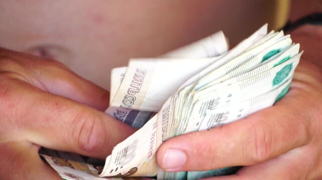 Money cash rubles hands counting Russian currency banknotes close-up finance earnings income budget wealth