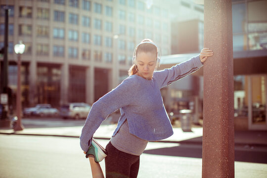 Woman stretching before run on city street