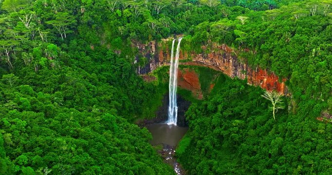 Aerial view of Chamarel Waterfall, plunging from verdant cliff into shadowy, the highest waterfall on the island, Mauritius island