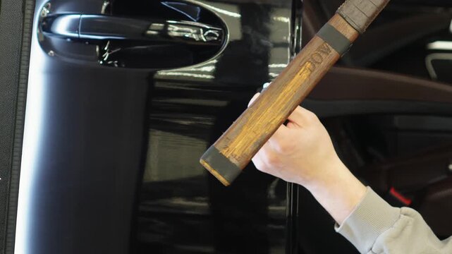 PDR. Process of paintless dent repair on car body. The mechanic at the auto shop with tools to repair dents in car body. Body repair. A specialist repairs a dent on the car body without painting. 