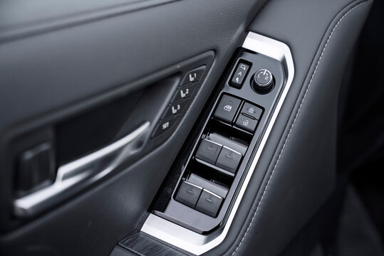 Close-up of a premium car's black leather door panel with silver trim. It features controls for electric windows, central locking, power mirrors, and the seat memory system (L1, L2, L3, SET).