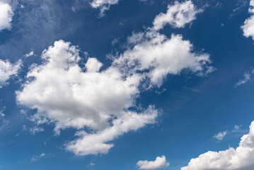 Fototapeta premium Blue sky with white fluffy summer clouds floating
