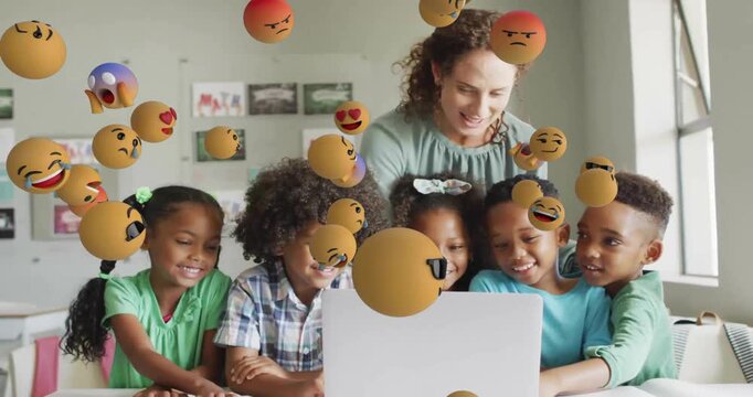 Animation of emoji icons over diverse schoolchildren and teacher using laptop