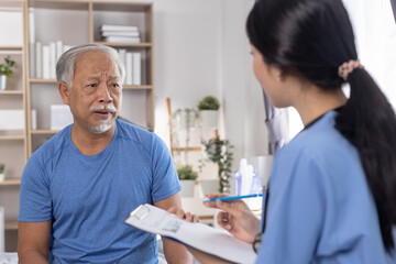 Obraz premium Senior man discussing health concerns with Nurse professional caregiver during home consultation. Concept of elderly care, medical advice, trust, support, Health checkup.