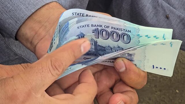 Pakistani bank currency 1000 rupees notes held in hands showcasing various denominations of banknotes with intricate designs