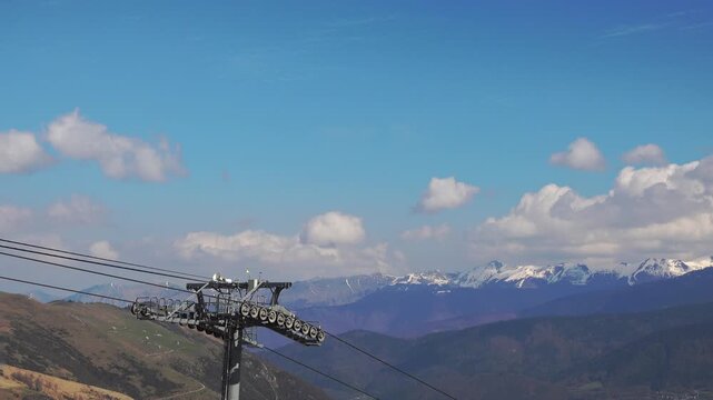 A cable car moves high above the mountains