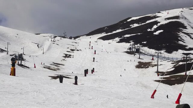 People ski down snowy slopes at a mountain