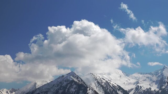 time lapse of clouds in the sky and snow covered mountains