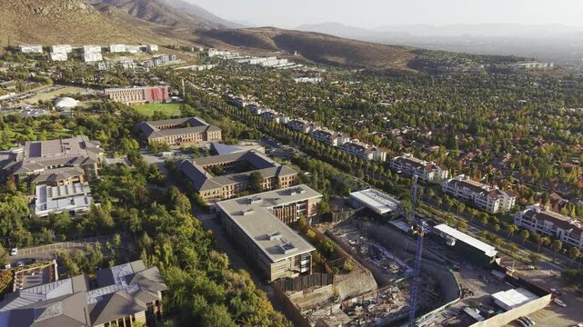 Aerial drone panorama slowly panning across the Universidad de los Andes campus, San Carlos de Apoquindo, Las Condes, Chile, 4K.