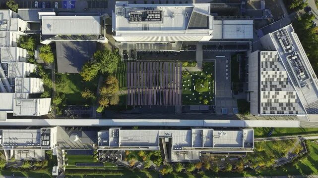 Top-down drone view looking directly at the modern rooftops and interior courtyards of Universidad del Desarrollo. Chile, 4K