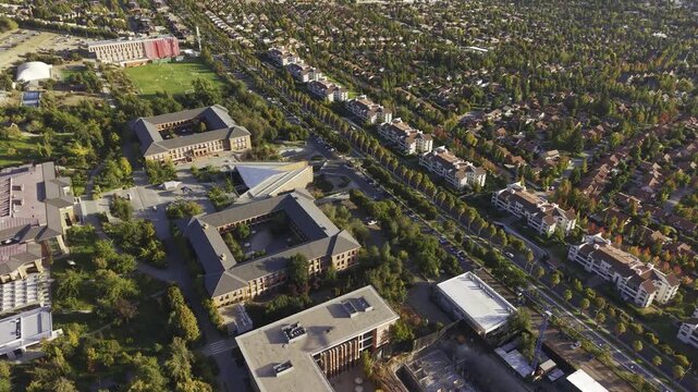 Wide drone shot tracking forward over Universidad de los Andes and nearby residential areas, San Carlos de Apoquindo, Las Condes, Chile, 4K.