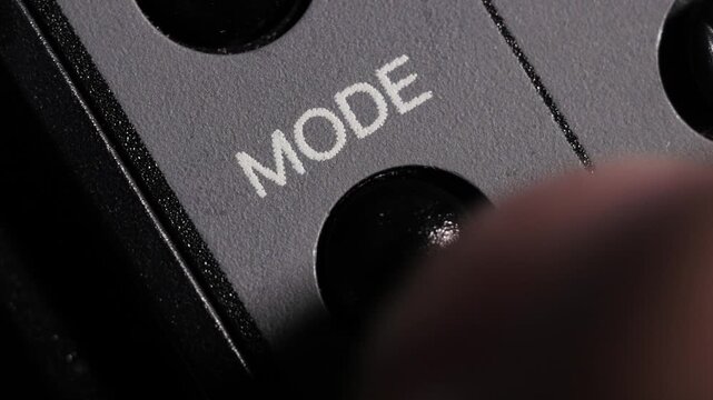 Macro close up of mode button pressed to switch camera settings and creative options
