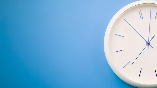 Minimalist white wall clock on a light blue background showing 1:54. Clean modern design symbolizing time, punctuality, and planning.