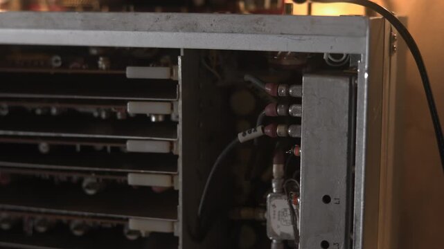 Power Supply Inspection. Detailed Examination Of Power Supply Unit Under Warm Lighting Conditions. Media