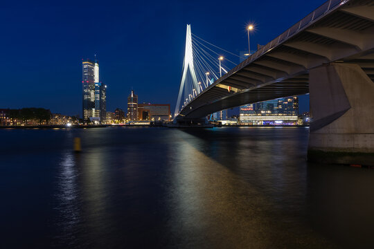 Night perspective of Erasmus Bridge in Rotterdam with city skyscrapers