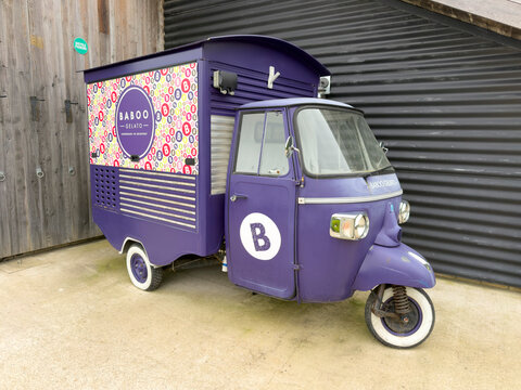 North Cadbury Yeovil England UK. 24.03.2026. A vibrant purple Ape Piaggio three-wheeled vehicle converted into a mobile gelato stand is parked on a concrete surface