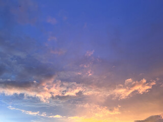Obraz premium Dramatic colorful sunset sky with orange, pink, and purple clouds at dusk, beautiful evening atmosphere nature landscape background, majestic golden hour light in the sky, serenity and hope concept.